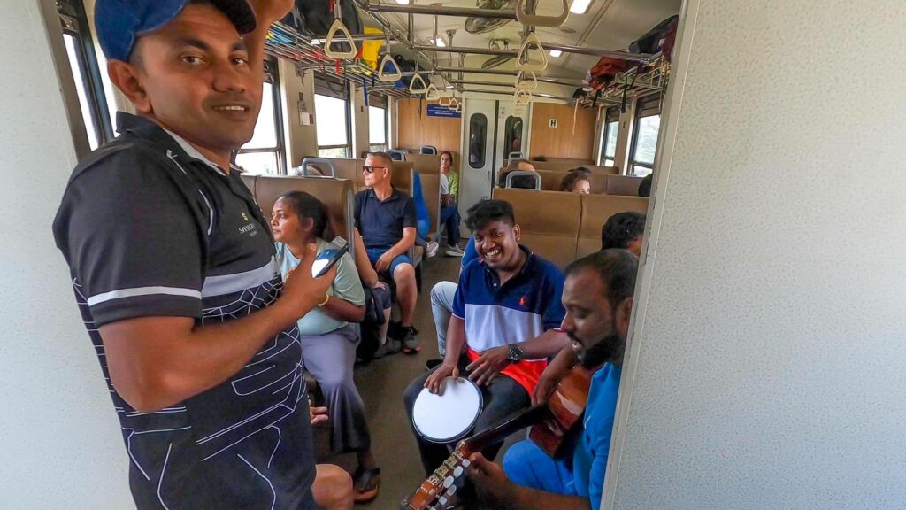 Lokalny ludia hraju na hudobne nastroje vo vlaku z kandy do ella na Sri lanke.
