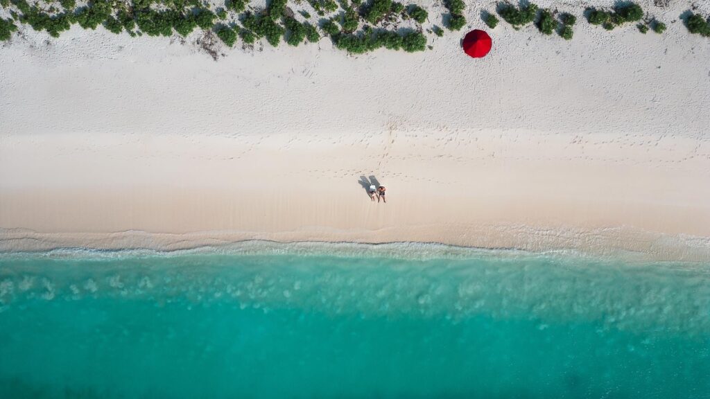 Tyrkysova plaz na ostrove Dhigurah,  Maldivy s cervenym slnecnikom.